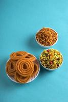 Indian Snack Chakli, chakali or Murukku and Besan Gram flour Sev and chivada or chiwada on blue background. Diwali Food photo