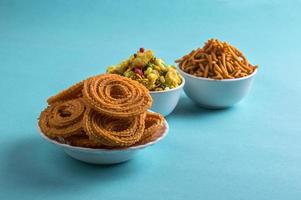 Indian Snack Chakli, chakali or Murukku and Besan Gram flour Sev and chivada or chiwada on blue background. Diwali Food photo