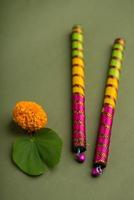 Indian Festival Dussehra and Navratri, showing golden leaf Bauhinia racemosa and marigold flowers with Dandiya sticks. photo