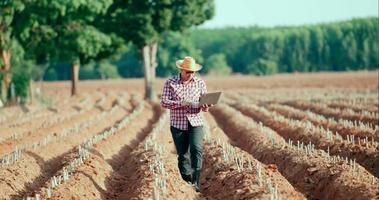 jovem agricultor verificando e coletando dados no laptop video