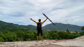 Professional male photographer on high mountain takes a picture photo