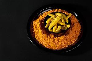 Turmeric powder and roots or barks on black background photo