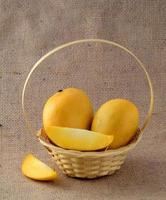 Mango fruit in basket on sack cloth background photo