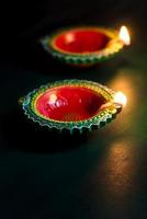 Happy Diwali - Clay Diya lamps lit during Diwali celebration. Greetings Card Design of Indian Hindu Light Festival called Diwali photo