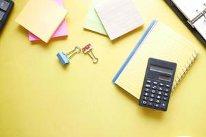 Close up of blue calculator and notepad on color background photo