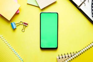 top view of smart phone and notepad on table photo