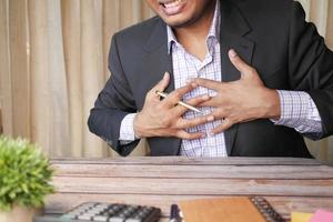 young man suffering pain in heart and holding chest with hand photo