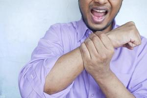 man suffering pain in hand close up photo