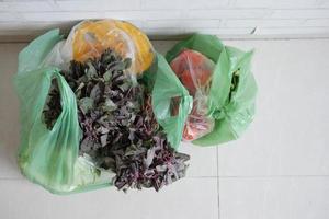 top view of vegetables in a plastic shopping bag on floor photo