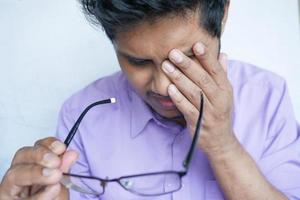 Close up of upset man suffering from strong eye pain photo