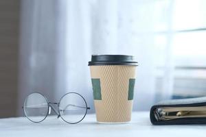 take away paper , eyeglass and notepad on table photo