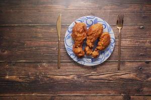 Filetes de pollo frito en la placa sobre fondo de madera foto