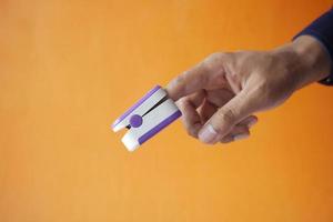 close up of man hand using pulse oximeter photo