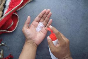 man's hand using liquid soap on black background photo