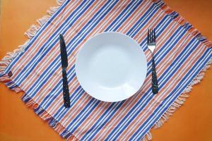 cutlery and empty plate on color background top down photo