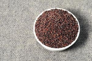 Brown Mustard Seeds in bowl on sackcloth photo