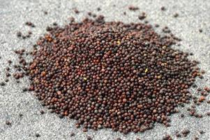 Montón de semillas de mostaza marrón sobre cilicio foto