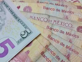 Economía y finanzas con dinero en dólares estadounidenses y mexicanos. foto