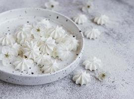 Small white meringues in the  ceramic bowl photo