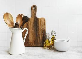 Kitchen utensils, tools and dishware on on the background white tile wall. photo