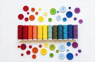 carretes de hilo y botones en los colores del arco iris foto