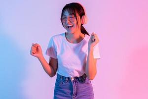 joven asiática está usando audífonos y escuchando música con entusiasmo