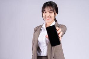 Joven empresaria asiática con teléfono sobre fondo blanco. foto