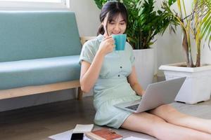joven mujer asiática que trabaja en línea desde casa foto