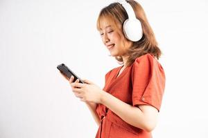 Joven asiática usando su teléfono y usando audífonos para disfrutar de la música