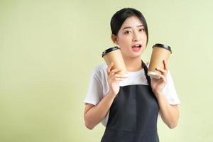 camarera asiática sosteniendo dos tazas de café foto