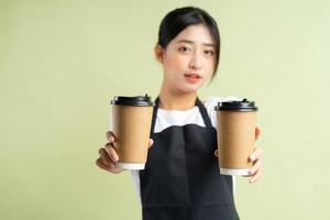 camarera asiática sosteniendo dos tazas de café foto