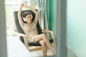 Woman lying on chair listening to relaxing music photo