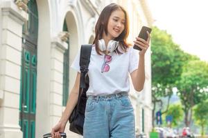 turista asiática está usando su teléfono para encontrar su camino