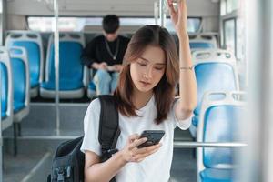 mujer asiática, utilizar, smartphone, en, autobús