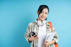 Portrait of Asian student on blue background photo