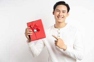 El empresario asiático está sosteniendo una caja de regalo roja sobre fondo blanco. foto