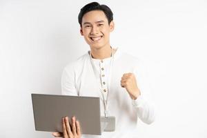 El empresario asiático está mostrando sentimientos de victoria mientras usa la computadora portátil