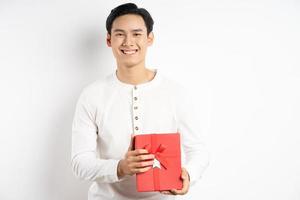 El empresario asiático está sosteniendo una caja de regalo roja sobre fondo blanco. foto