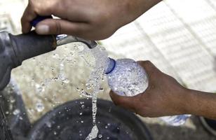 Filling bottle in fountain photo