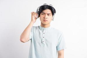 el hombre asiático estaba molesto por el sonido proveniente de los auriculares inalámbricos foto