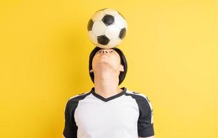 el hombre asiático está rebotando la pelota con la cabeza foto