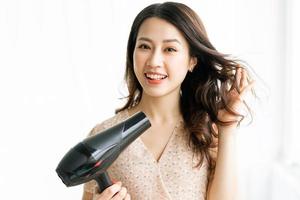 mujer sentada secando el cabello con una expresión feliz foto