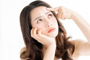 Asian woman sitting makeup in front of mirror photo