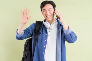 retrato del guapo estudiante asiático en el teléfono foto