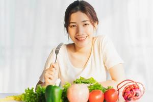 Young woman is eating green vegetables for weight loss photo