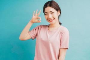 Portrait of girl raising hands of acceptance on blue background photo