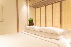 Decoración de almohadas blancas en la cama en el dormitorio del resort de hotel de lujo foto