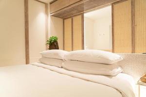 Decoración de almohadas blancas en la cama en el dormitorio del resort de hotel de lujo
