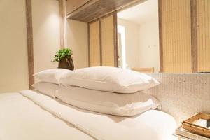 Decoración de almohadas blancas en la cama en el dormitorio del resort de hotel de lujo