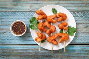 Brocheta de salchicha frita con salsa para mojar foto